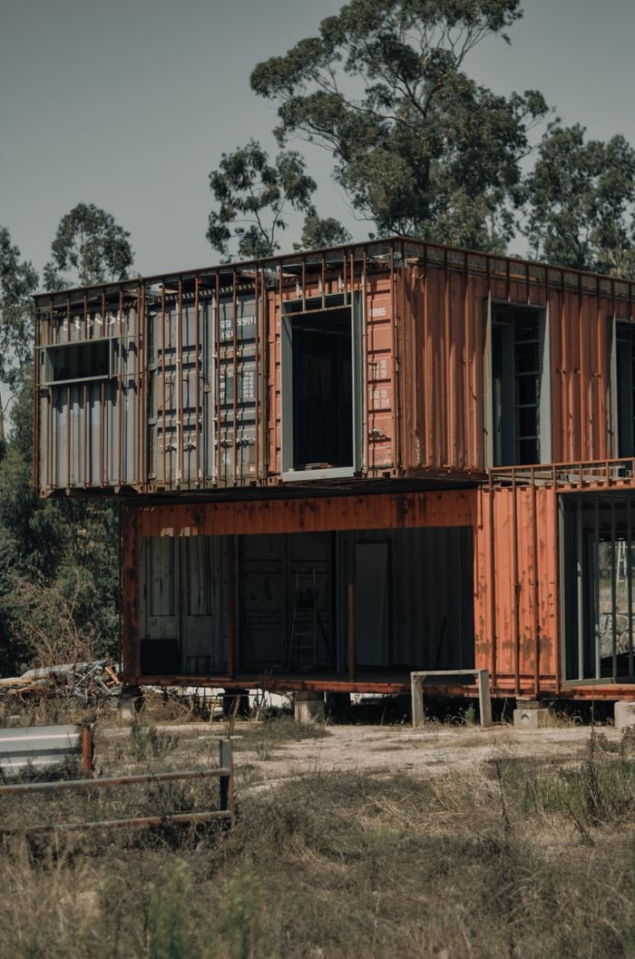Mastering the First Impression: Your intriguing post title goes here A rustic, container house structure set in a natural, wooded environment.