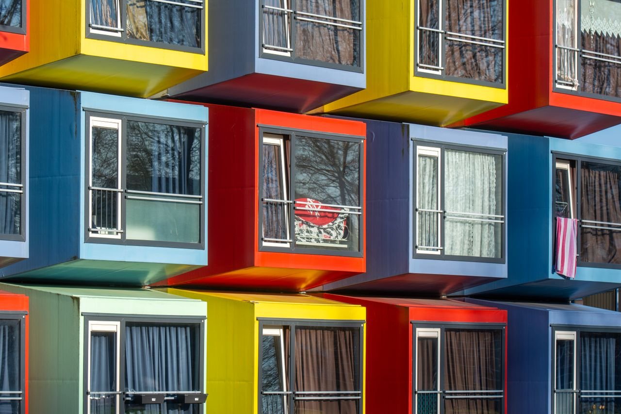 Services-02 Vibrant stack of modular apartments creating a colorful urban facade in Almere, Netherlands.